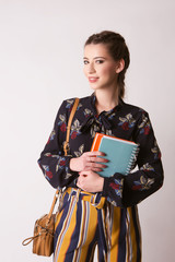 Fototapeta premium Cute teenage girl in casual clothes holding books, 