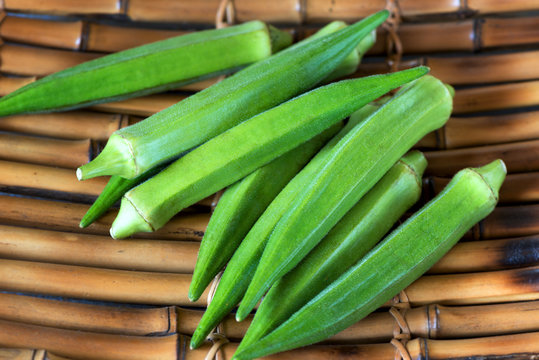 A heap of okra or Lady's fingers on bamboo background