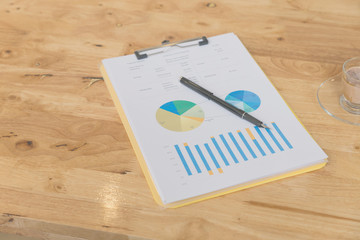 pen, business document and chocolate drink in a glass