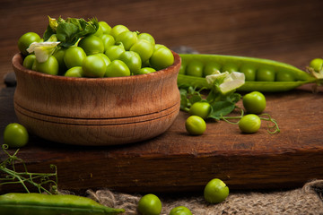Fresh organic green peas on a wooden background.Rustic style.