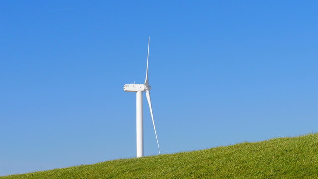 Wind turbine behind inclining levee Eemshaven The Netherlands
