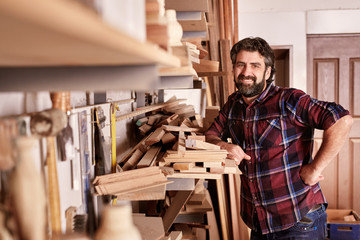 Naklejka na ściany i meble Carpentry business owner standing smiling in his workshop