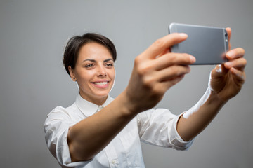 Attractive young woman takes a selfie with a smartphone