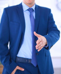 Business and office concept - handsome businessman with open hand ready for handshake