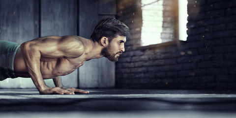 Fototapeta na wymiar Muscular and strong guy exercising.