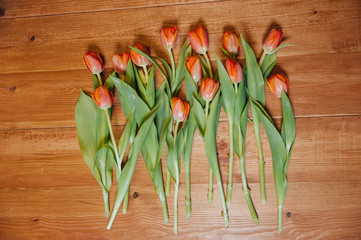 orange tulips over wooden table background
