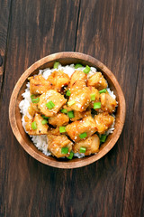 Asian chicken meat with orange sause and green onion, top view