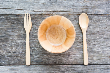 Empty wooden bowl, fork and tray top view on old wooden table. F