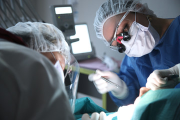modern dental surgery, face of a female doctor working on a patient - 103999023