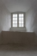 Old window of medieval castle with wooden frame. Thick wall. View from inside. Vertical image.