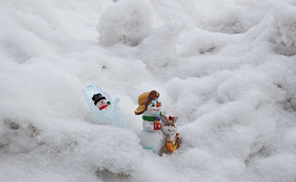 Игрушечные снеговики идут по снегу после праздника.