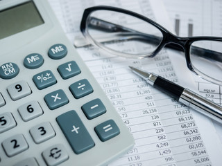 Business concept with calculator,pen,glasses and financial documents.