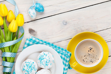 Easter background with blue and white eggs, yellow tulips and tr