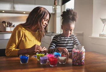 Woman and young girl creating beaded crafts