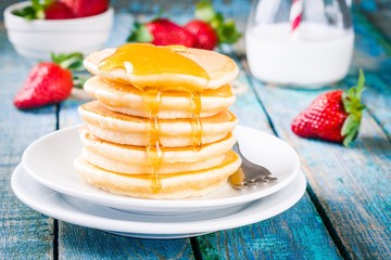 Homemade pancakes with honey and strawberries