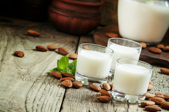 Almonds and milk, old wooden background, rustic style, selective
