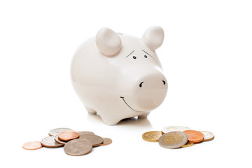 Porcelain pig bank with Euro coins and American cents