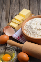 Ingredients for baking - butter, eggs and flour. Rustic background. Selective focus.