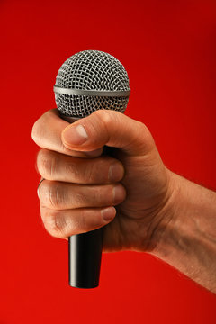 Man hand with microphone over red background