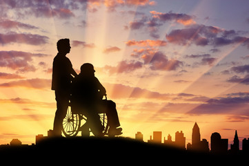 Silhouette of  man looking after  disabled person