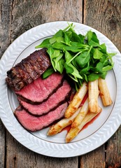 Medium rare steak with asparagus and baby spinach.