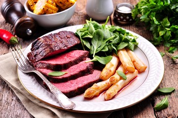 Medium rare steak with asparagus and baby spinach.