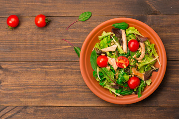 Fresh salad with chicken breast, arugula and tomato. Top view
