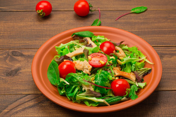 Fresh salad with chicken breast, arugula and tomato.