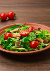 Fresh salad with chicken breast, arugula and tomato.