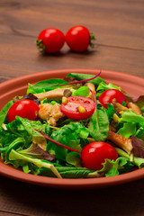 Fresh salad with chicken breast, arugula and tomato.