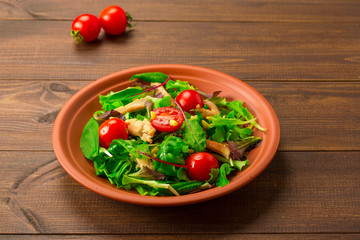Fresh salad with chicken breast, arugula and tomato.