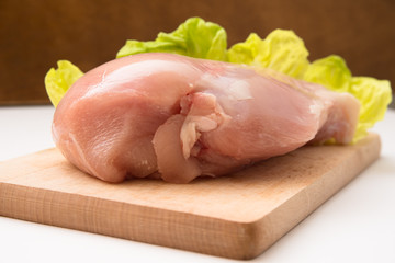 Petto di pollo fresco su tagliere in legno