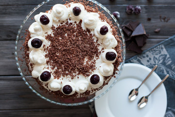 Black forest cake decorated with whipped cream and cherries. 