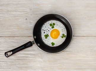pan with fried eggs on a wooden background