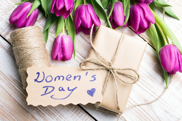 Women's day card and a bouquet of beautiful tulips on wooden background