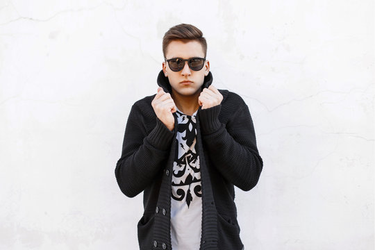 Young Handsome Man In Sunglasses And A Sweater On A White Bg