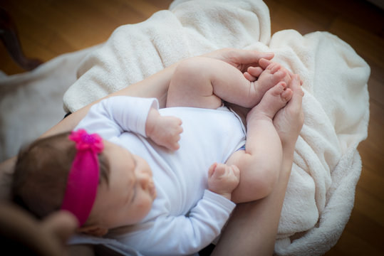 Hands holding caucasian sleeping newborn baby girl 