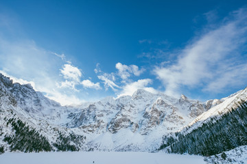 Sunny winter day in Polish Tatra mountains, frozen Morskie Oko lake