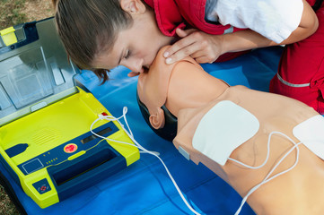 CPR training with defibrillator and dummy  - obrazy, fototapety, plakaty