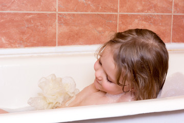 Obraz na płótnie Canvas little girl taking bath with foam