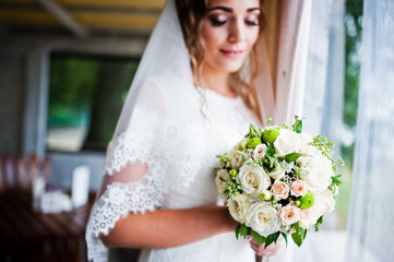 Charming bride looked at wedding bouquet at her hands