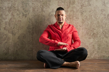 Fototapeta premium Portrait of a young man, in red shirt and black slacks, hairstyl