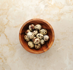 Quail eggs in a plate on a marble background. The view from the