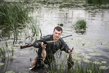 Hunter man with proie après une chasse réussie à travers les zones humides