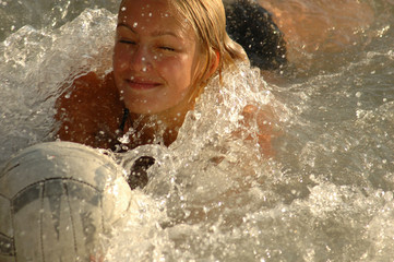 girl with a ball enjoys the surf