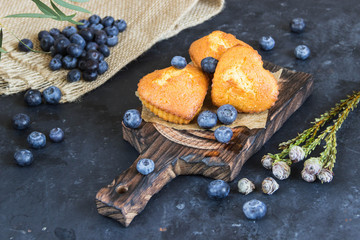 Fototapeta na wymiar Muffins with blueberry on wooden Board, flowers
