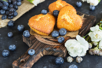 Muffins with blueberry on wooden Board, flowers