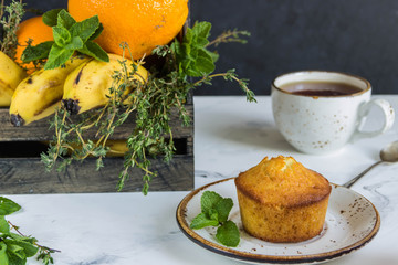Fruit muffins  from oranges, mint and wooden box with fruits,cup tea
