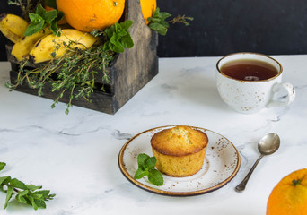 Fruit muffins  from oranges, mint and wooden box with fruits,cup tea.