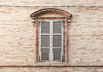 Old window shutters in ancient stone wall